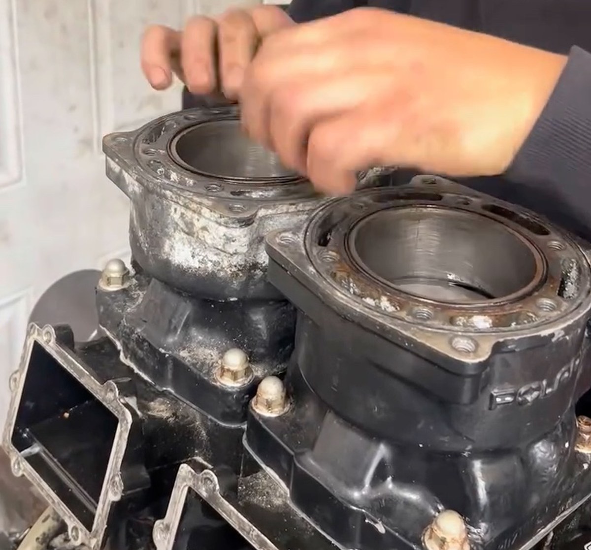 A two-stroke top end off a jet ski, with scored cylinder walls and corrosion on the deck