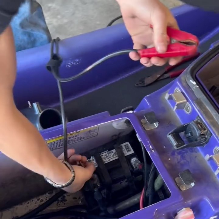 A charger being connected to a jet ski battery