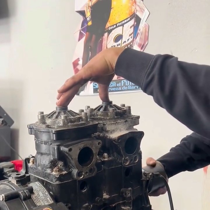 A Polaris twin-cylinder top end apart on the workbench